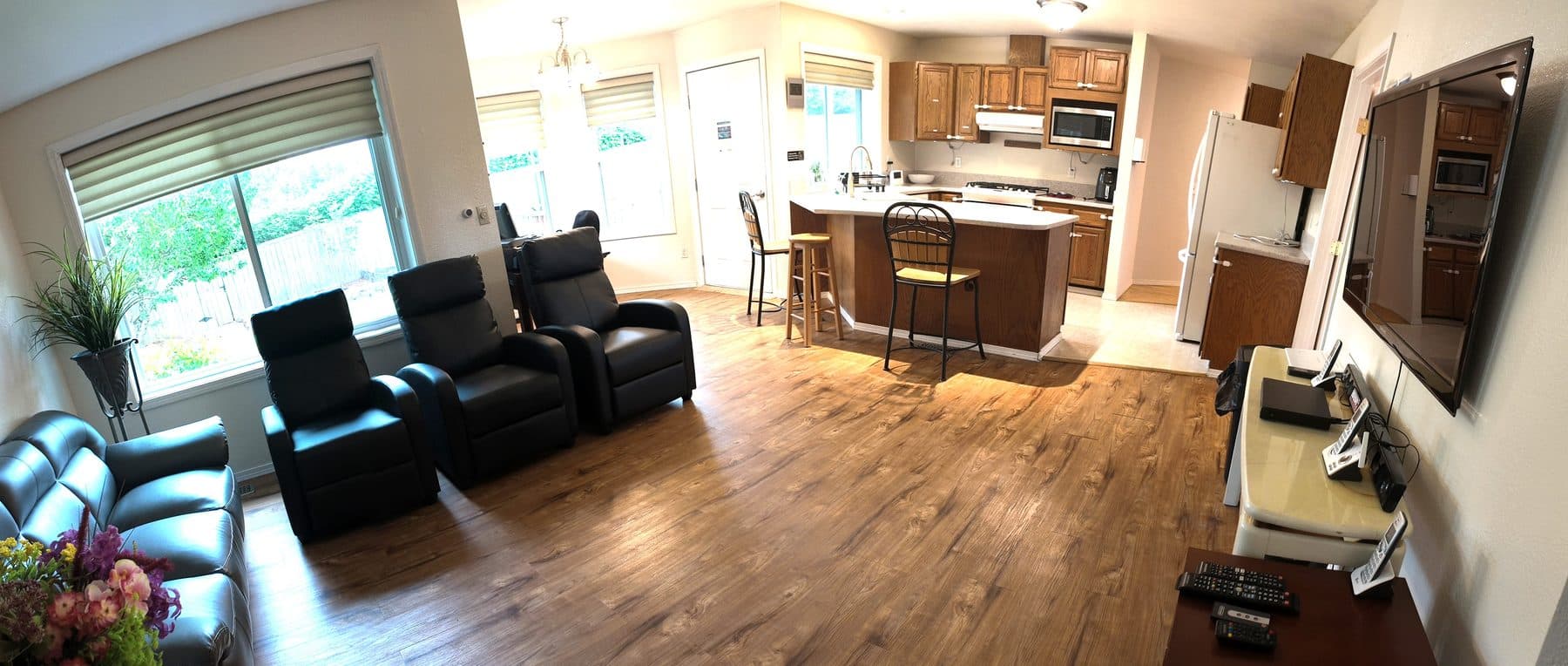 The living room at Puyallup Bliss, with recliner seating open to the kitchen